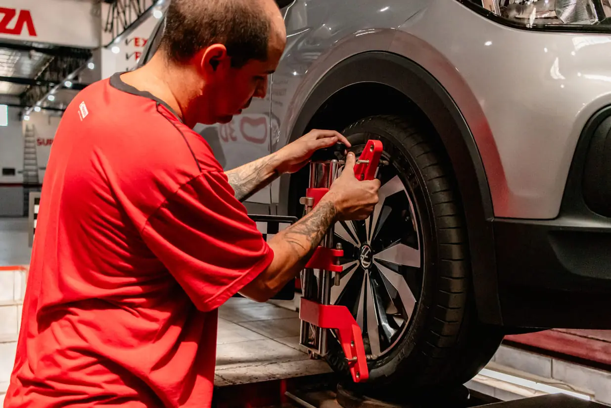 Mecânico da Big Pneus instalando o equipamento de alinhamento 3D na roda de um carro